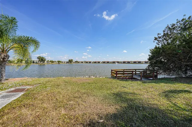 a view of swimming pool with outdoor seating and lake in the back