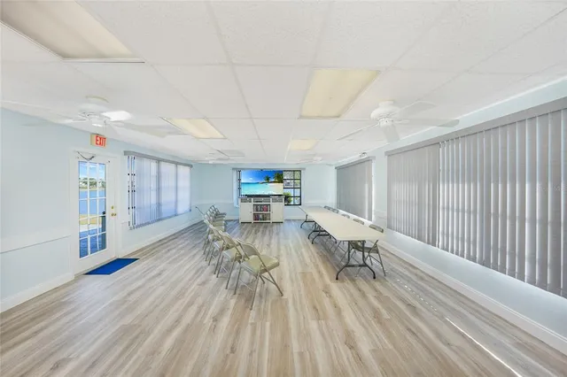 a large kitchen with a table chairs sink and wooden floor
