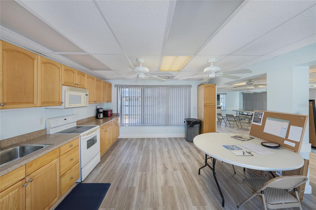 25225 Rampart Boulevard, Unit 1604 Punta Gorda, FL 33983 - Photo 35 of 39 a large kitchen with a table chairs sink and wooden floor