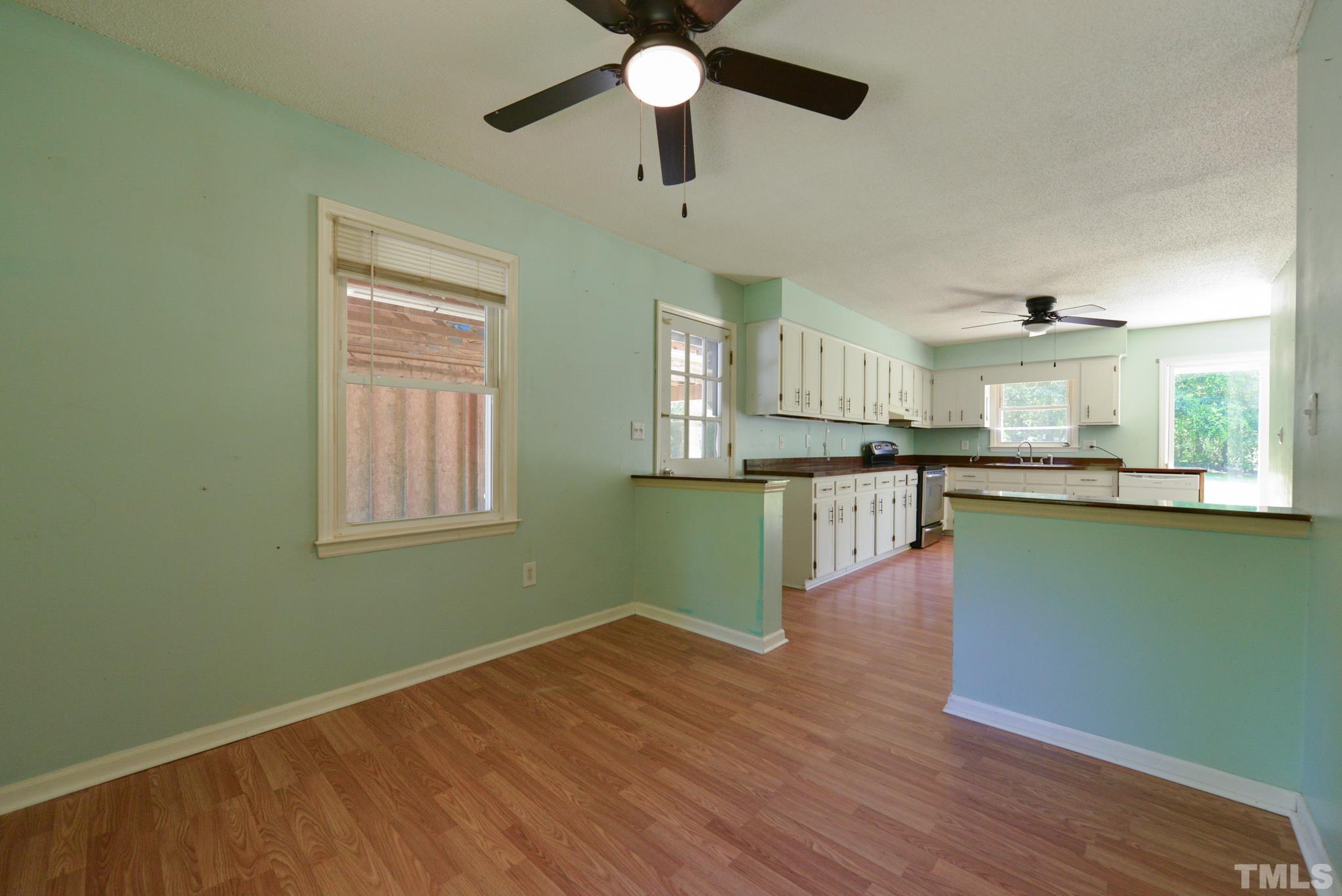 119 Mt Pleasant Road Willow Spring, NC 27592 - Photo 11 of 22 a view of a kitchen with wooden floor a sink a refrigerator and window