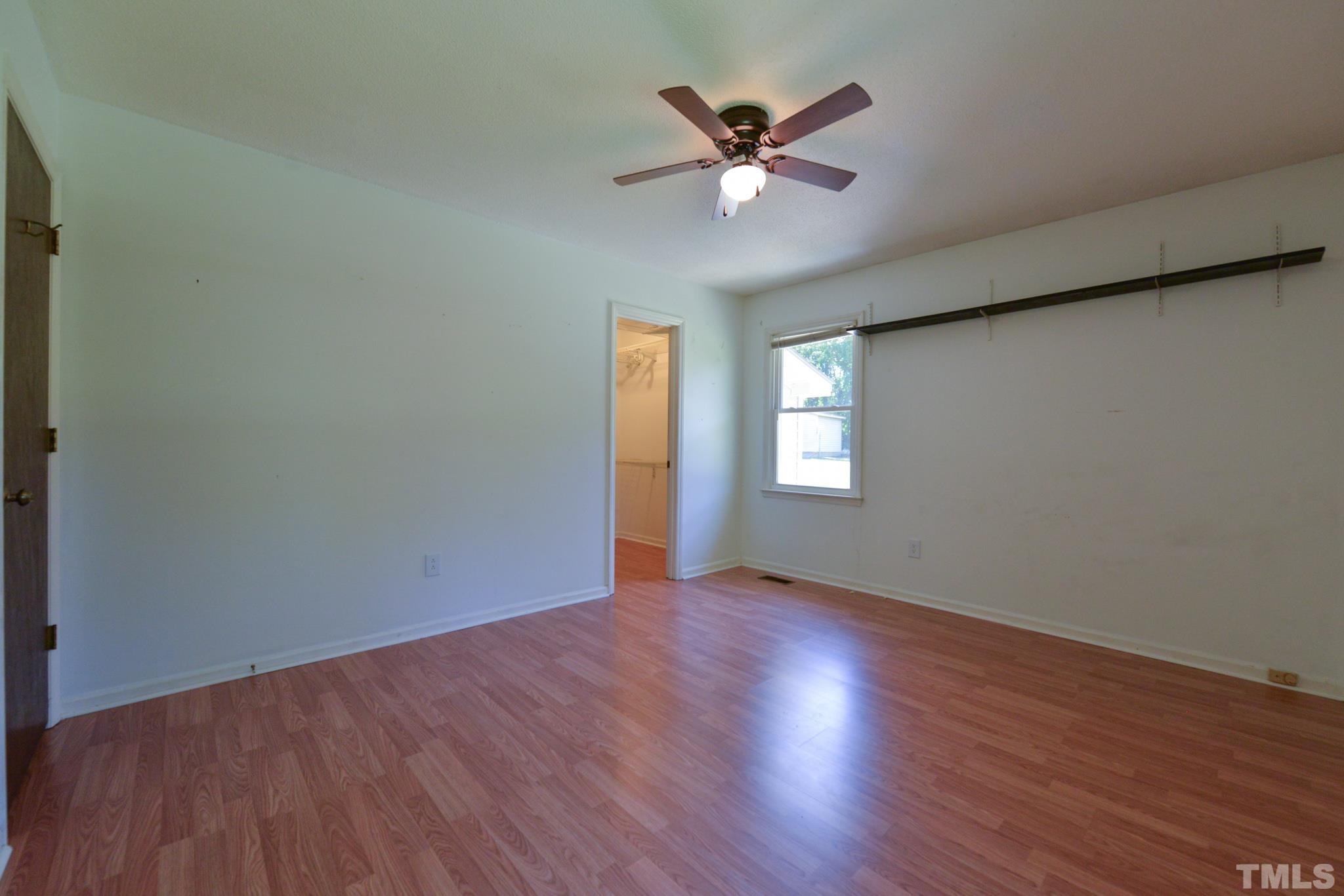 119 Mt Pleasant Road Willow Spring, NC 27592 - Photo 13 of 22 a view of an empty room with wooden floor and a window