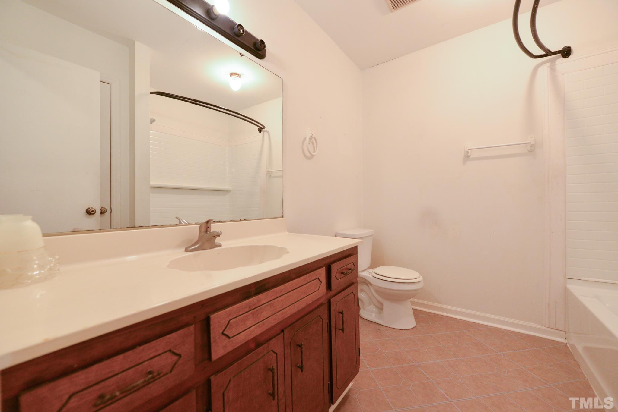 119 Mt Pleasant Road Willow Spring, NC 27592 - Photo 15 of 22 a bathroom with a granite countertop sink a toilet and a mirror
