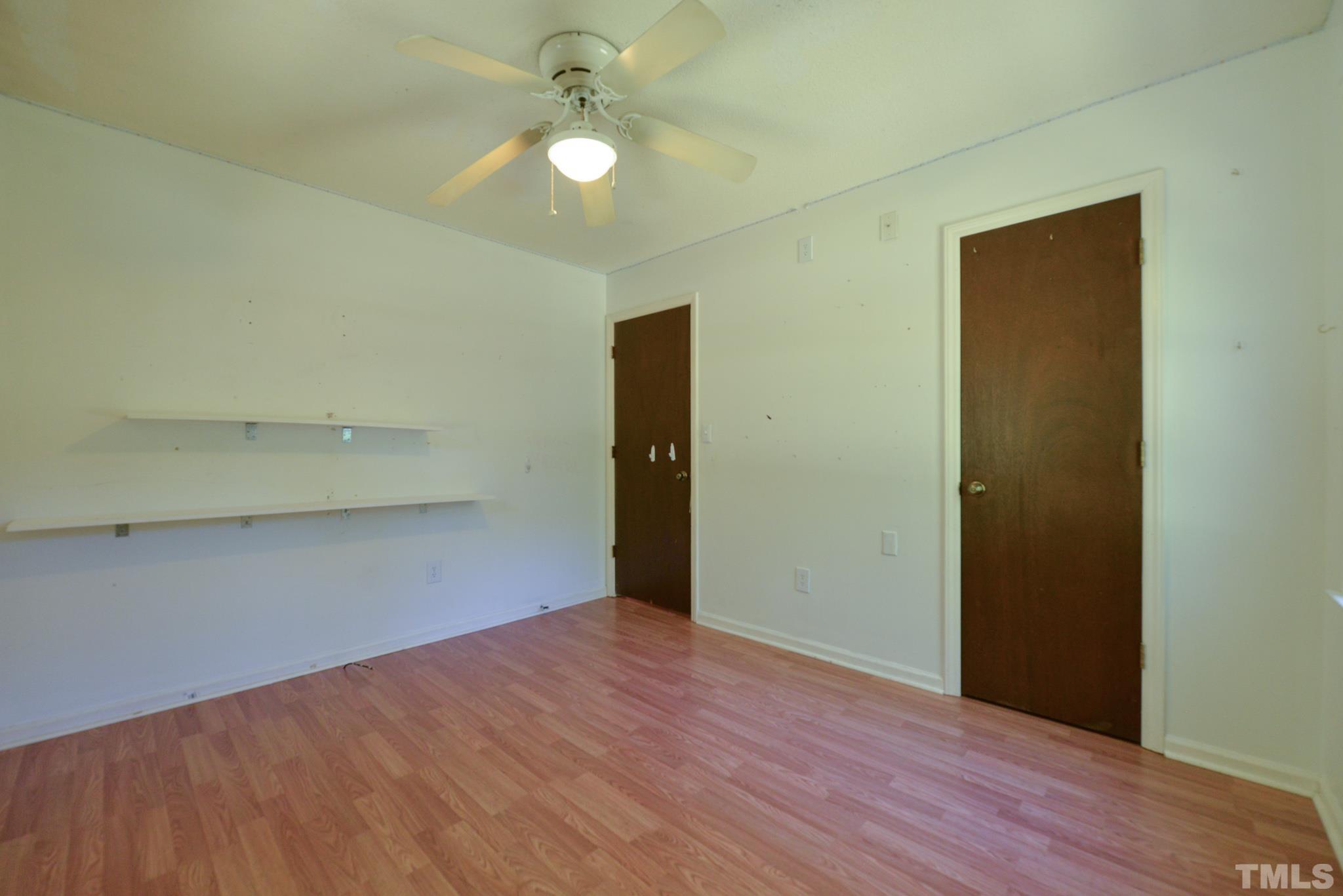 119 Mt Pleasant Road Willow Spring, NC 27592 - Photo 18 of 22 an empty room with wooden floor closet and fan
