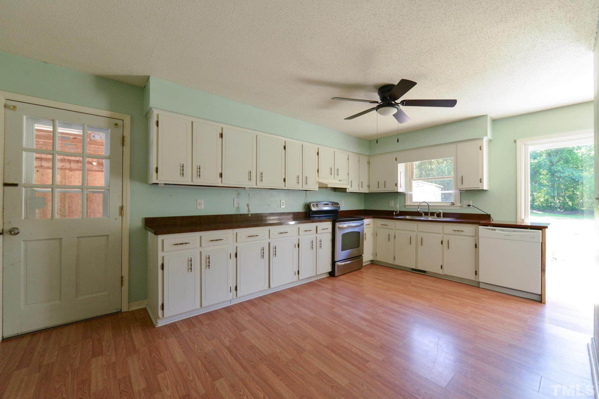 119 Mt Pleasant Road Willow Spring, NC 27592 - Photo 7 of 22 a kitchen with granite countertop white cabinets and white appliances