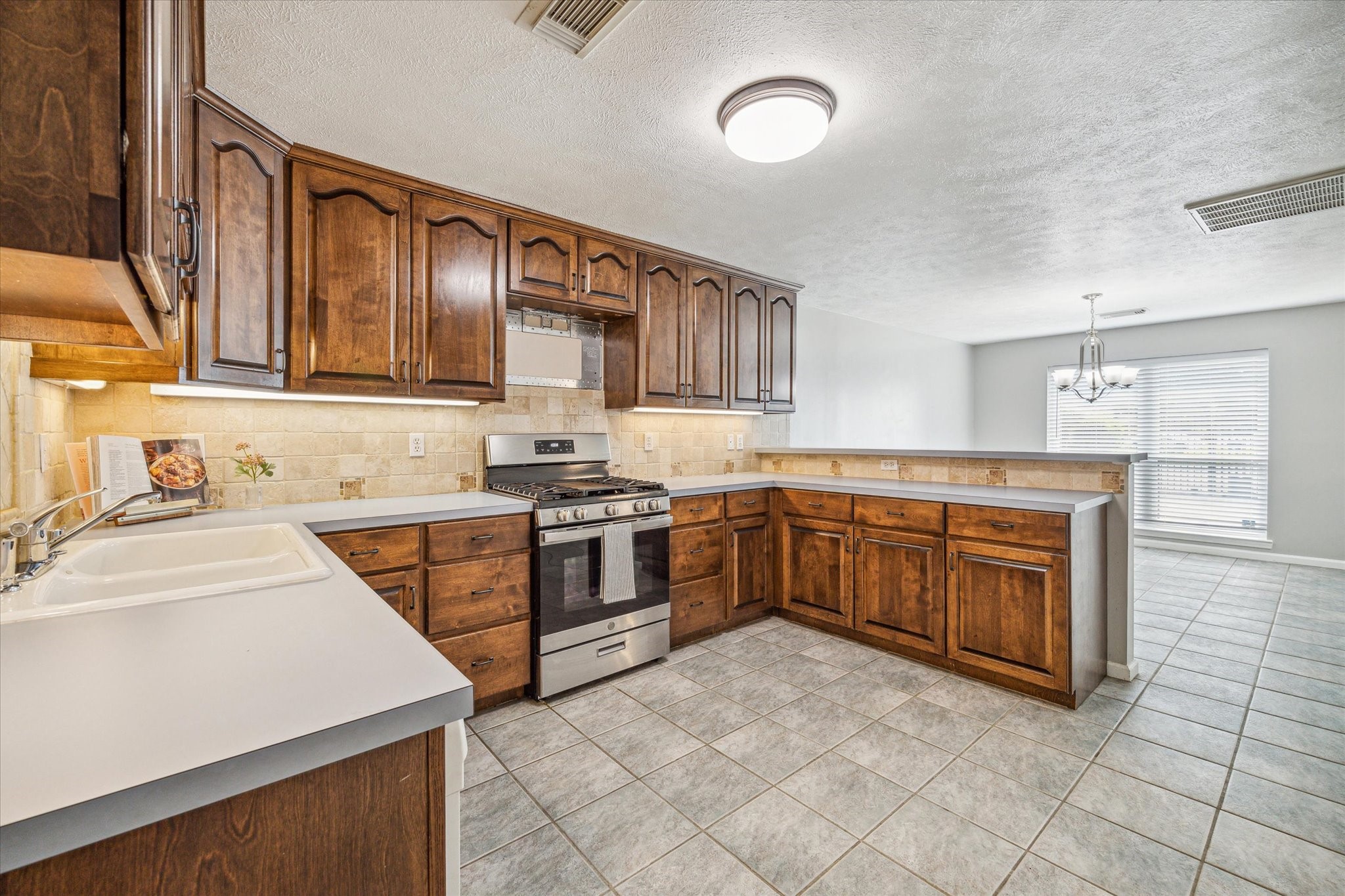 3613 Lazy Spring Drive Houston, TX 77080 - Photo 5 of 22 a kitchen with stainless steel appliances sink a stove and cabinets