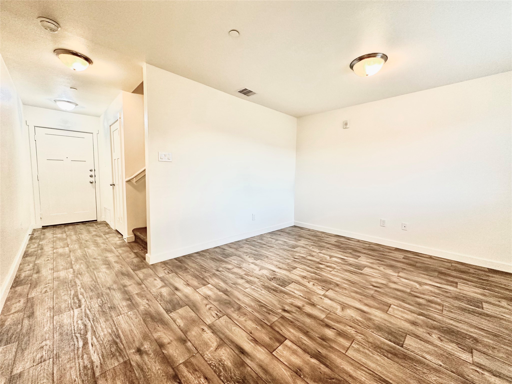21155 Gosling Road, Unit 6C Spring, TX 77388 - Photo 3 of 20 (First Floor) View from front door into living room with stairwell, large coat, closet underneath the stairs, and the back door.