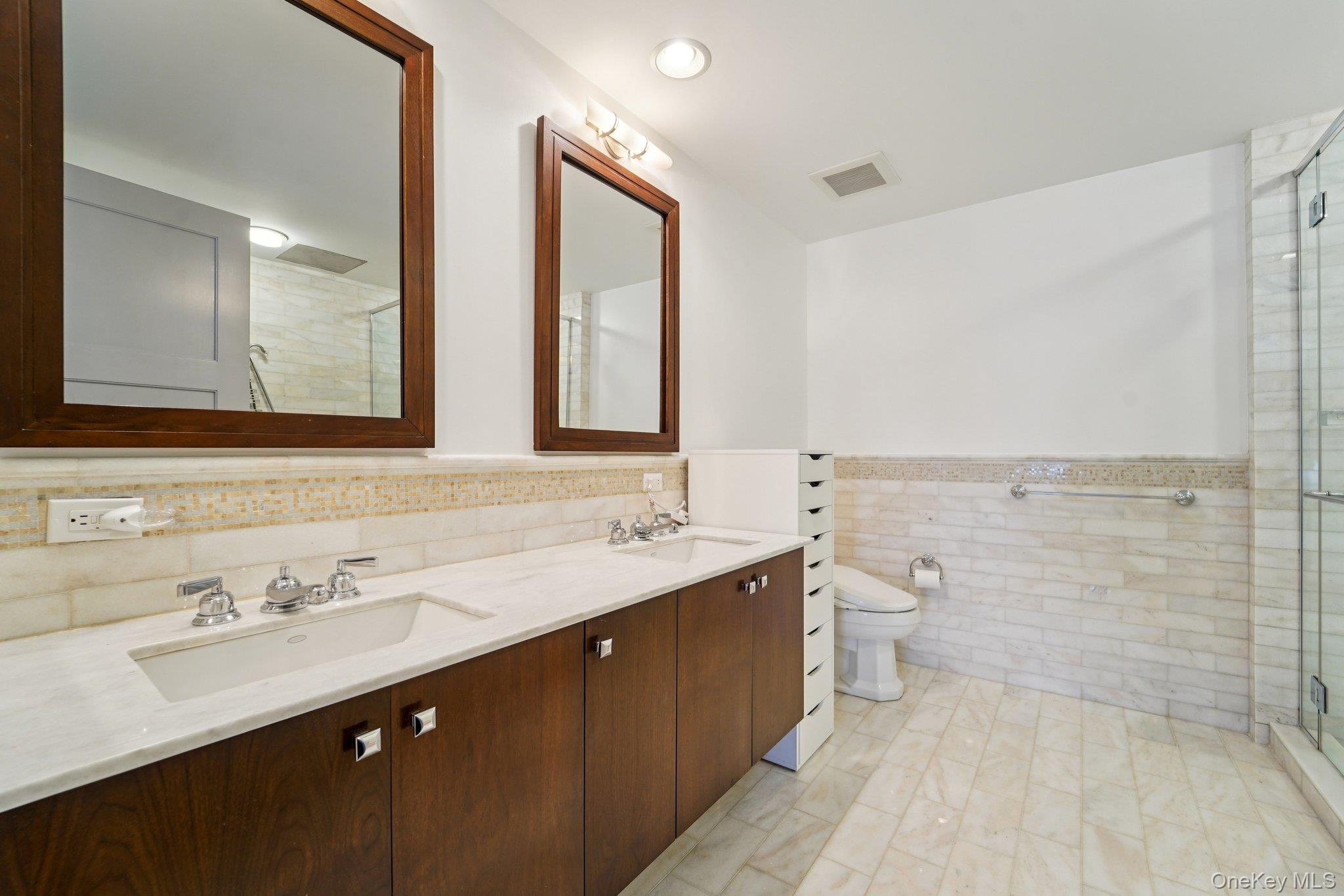 1 Renaissance Square, Unit 25G White Plains, NY 10601 - Photo 11 of 23 a bathroom with a double vanity sink toilet and mirror