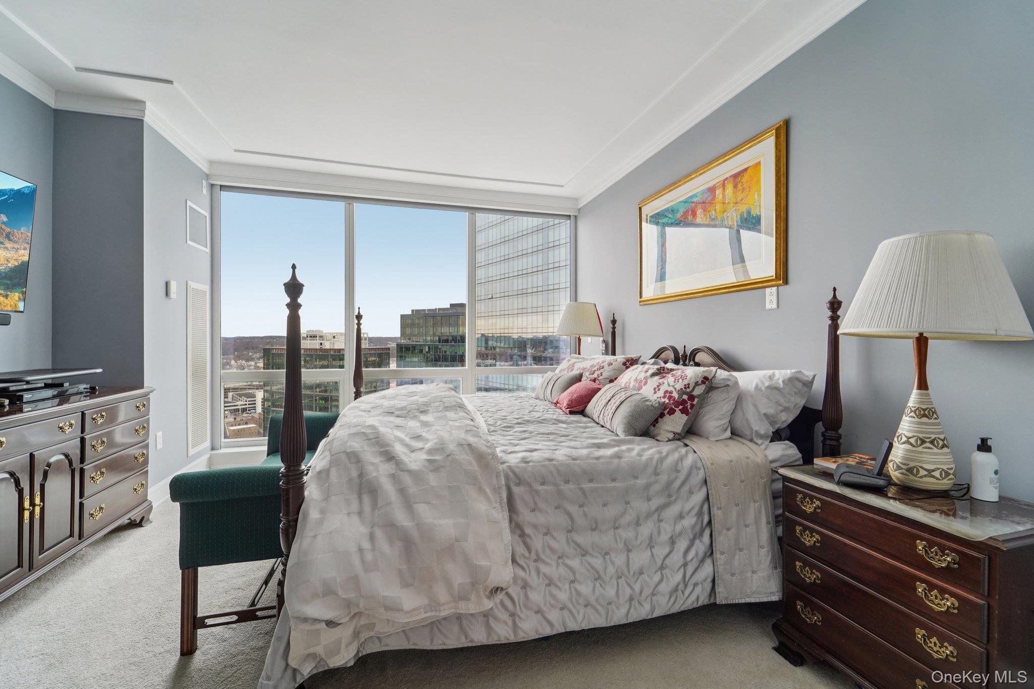 1 Renaissance Square, Unit 25G White Plains, NY 10601 - Photo 9 of 23 a bedroom with a bed and a lamp on dresser