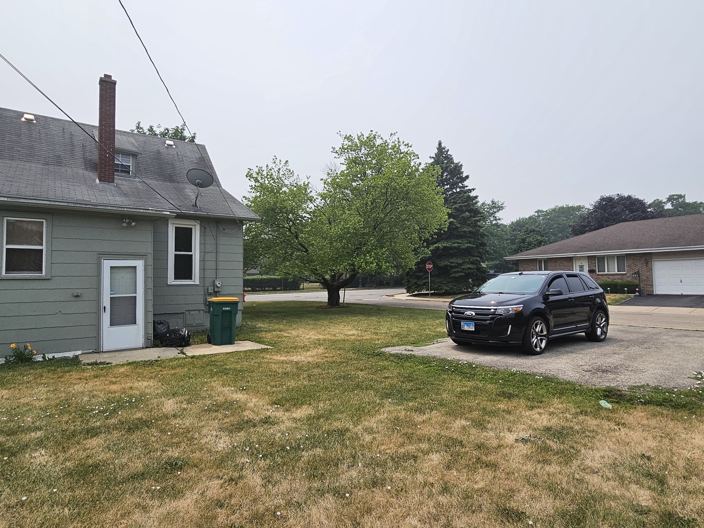825 Black Road Joliet, IL 60435 - Photo 21 of 22 a view of a house with a big yard and a car parked