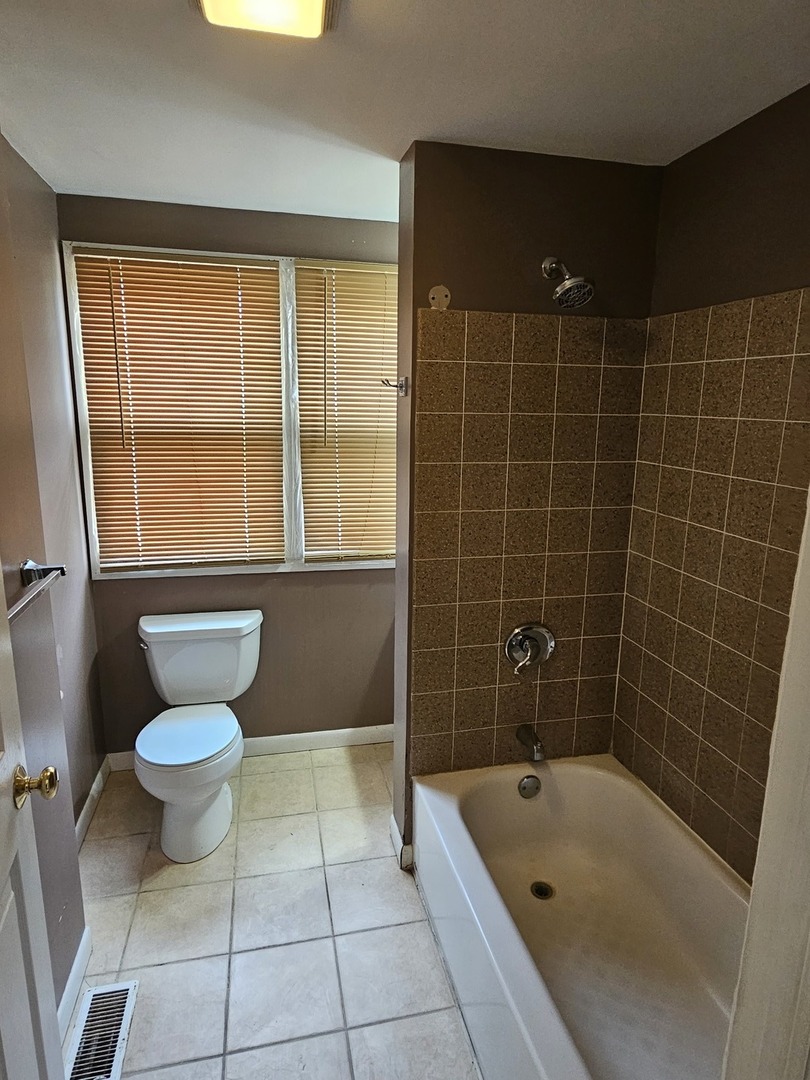 825 Black Road Joliet, IL 60435 - Photo 9 of 22 a bathroom with a bathtub and a toilet
