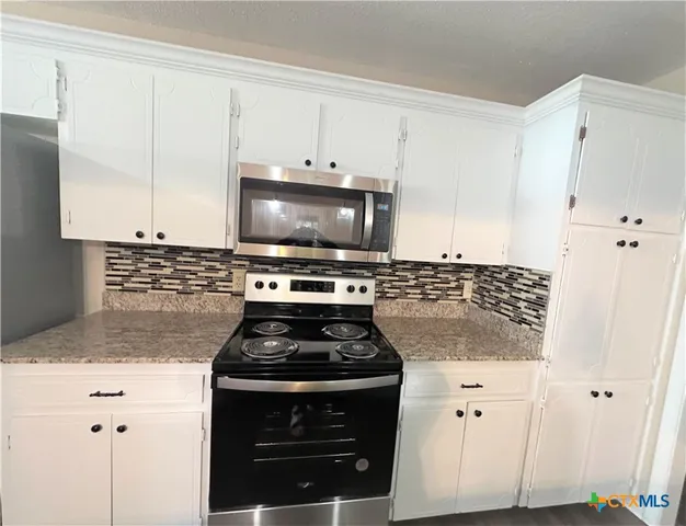 a kitchen with appliances a sink and a stove