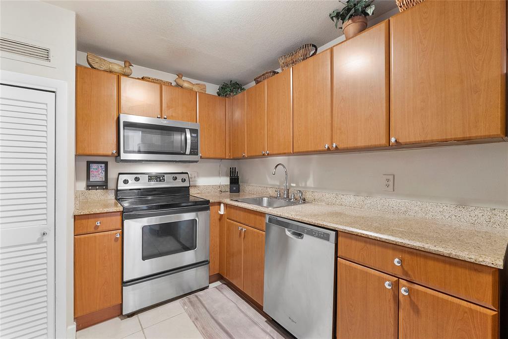 1900 South Ocean Boulevard, Unit 4H Pompano Beach, FL 33062 - Photo 3 of 35 a kitchen with a sink stove and microwave