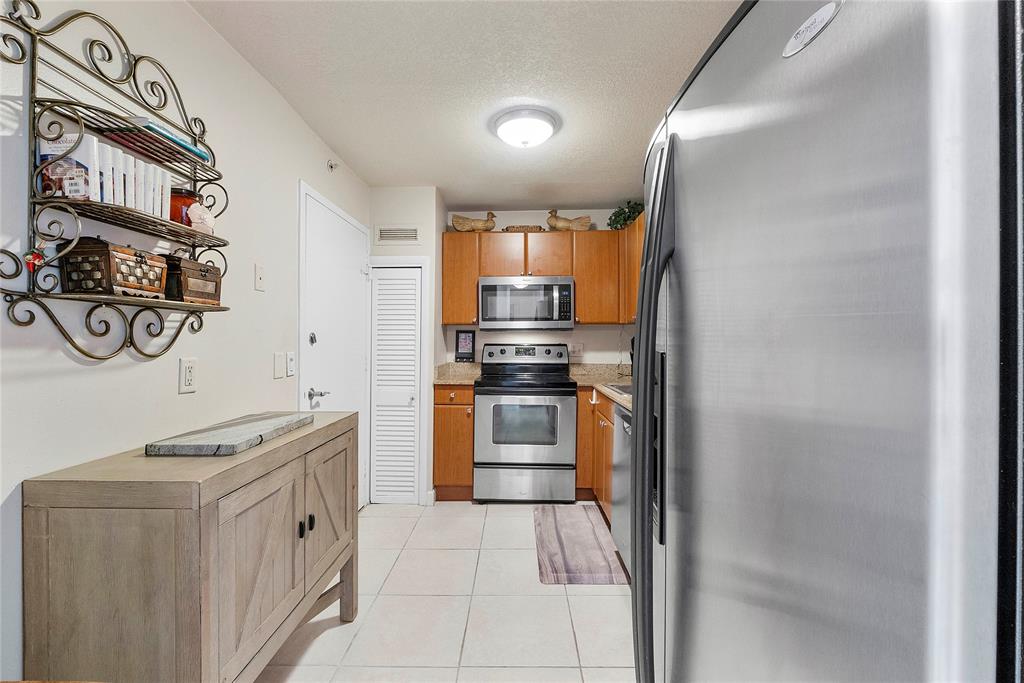 1900 South Ocean Boulevard, Unit 4H Pompano Beach, FL 33062 - Photo 4 of 35 a kitchen with stainless steel appliances granite countertop a stove and a refrigerator