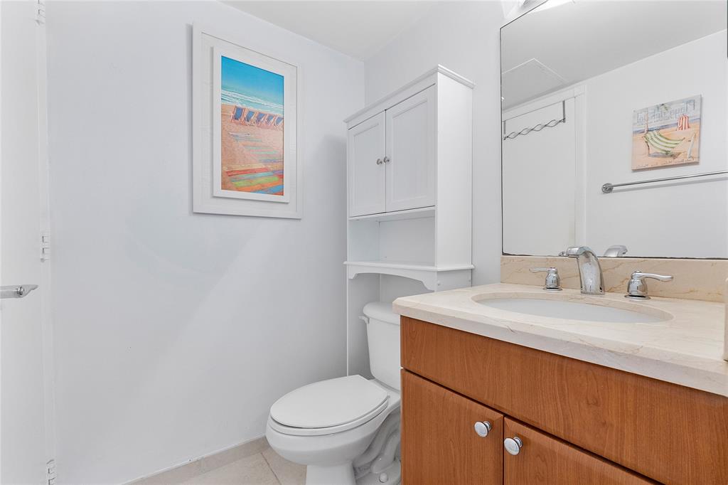 1900 South Ocean Boulevard, Unit 4H Pompano Beach, FL 33062 - Photo 5 of 35 a bathroom with a granite countertop toilet sink and mirror