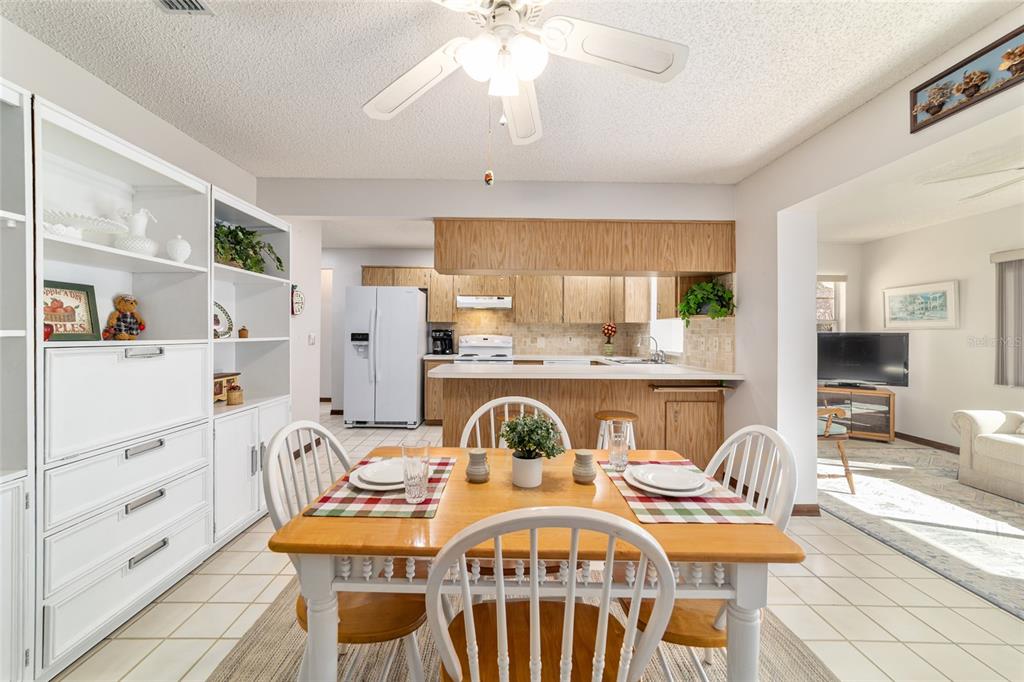 8530 Southwest 92 Street, Unit D Ocala, FL 34481 - Photo 12 of 42 a kitchen with stainless steel appliances granite countertop a stove a sink dishwasher a dining table and chairs with wooden floor