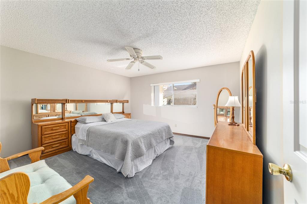 8530 Southwest 92 Street, Unit D Ocala, FL 34481 - Photo 22 of 42 a bedroom with a bed and dresser with mirror