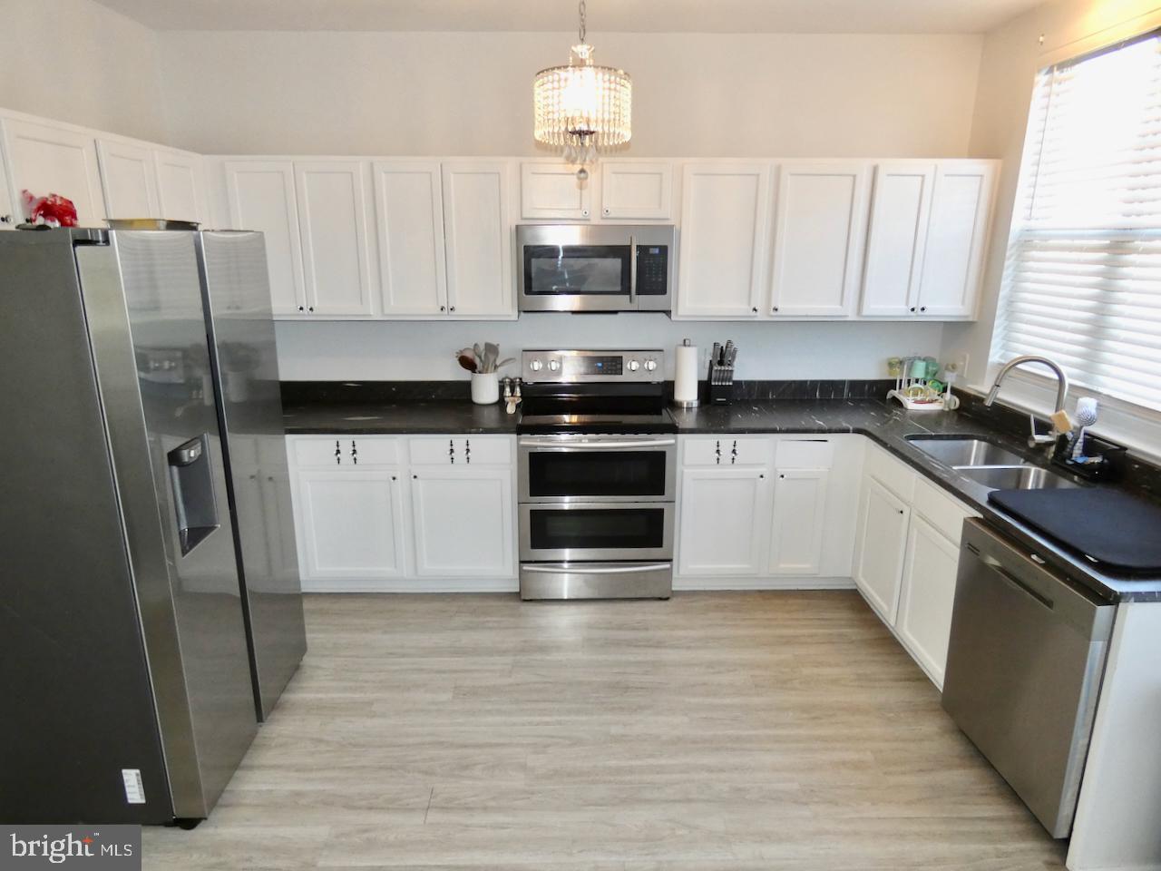 15 Wicklow Road Bear, DE 19701 - Photo 17 of 53 a kitchen with granite countertop a refrigerator a stove a microwave and cabinets
