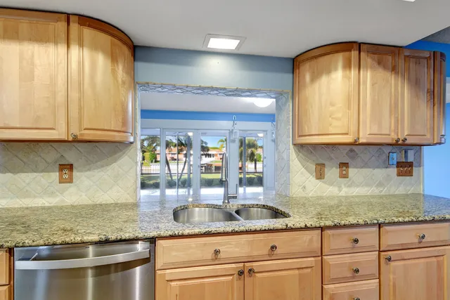 a kitchen with granite countertop stainless steel appliances a sink and a granite counter tops