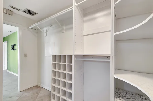 a view of walk in closet with empty racks
