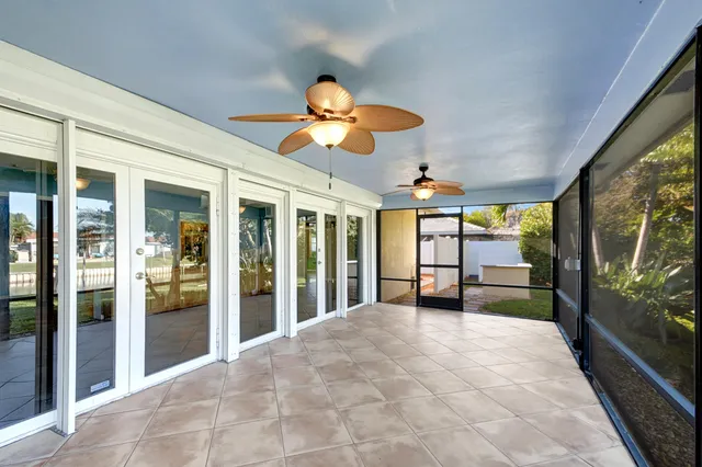 a view of a house with a big yard and palm trees