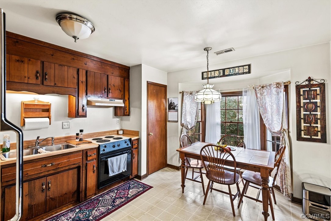 7830 Brightridge Road Chesterfield, VA 23832 - Photo 7 of 18 a kitchen with stainless steel appliances granite countertop a stove a sink dishwasher a dining table and chairs with wooden floor