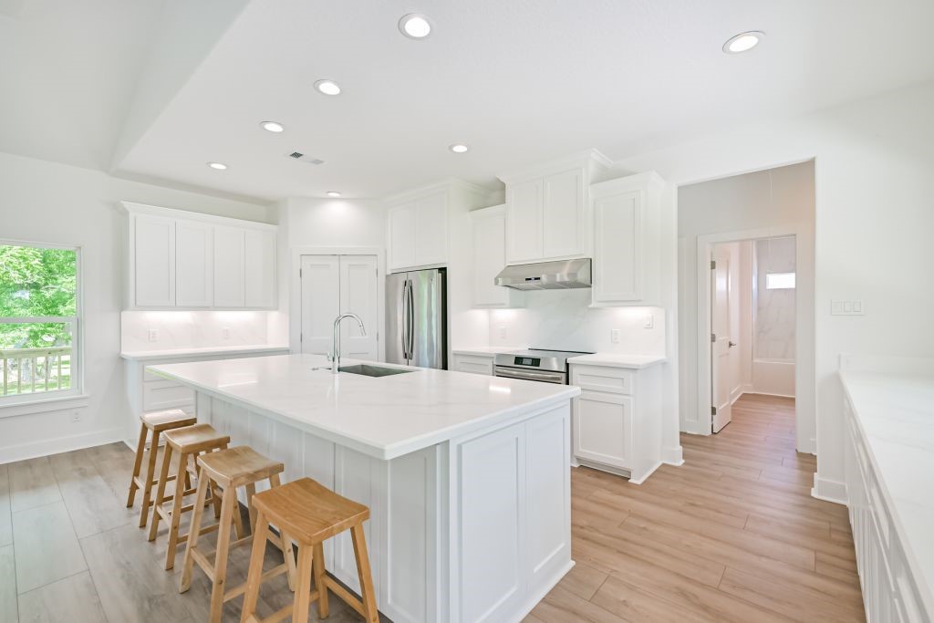 4294 Brazos River Road, Unit CR400 Freeport, TX 77541 - Photo 26 of 50 a kitchen with stainless steel appliances a stove a sink a refrigerator and a dining table with wooden floor