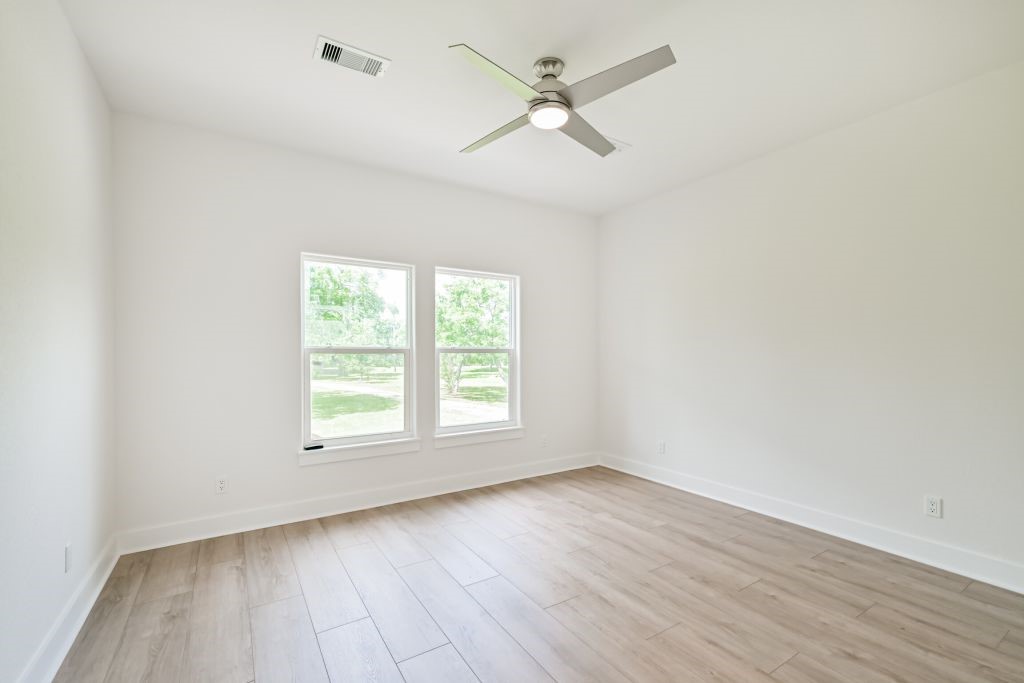 4294 Brazos River Road, Unit CR400 Freeport, TX 77541 - Photo 36 of 50 an empty room with wooden floor ceiling fan and windows
