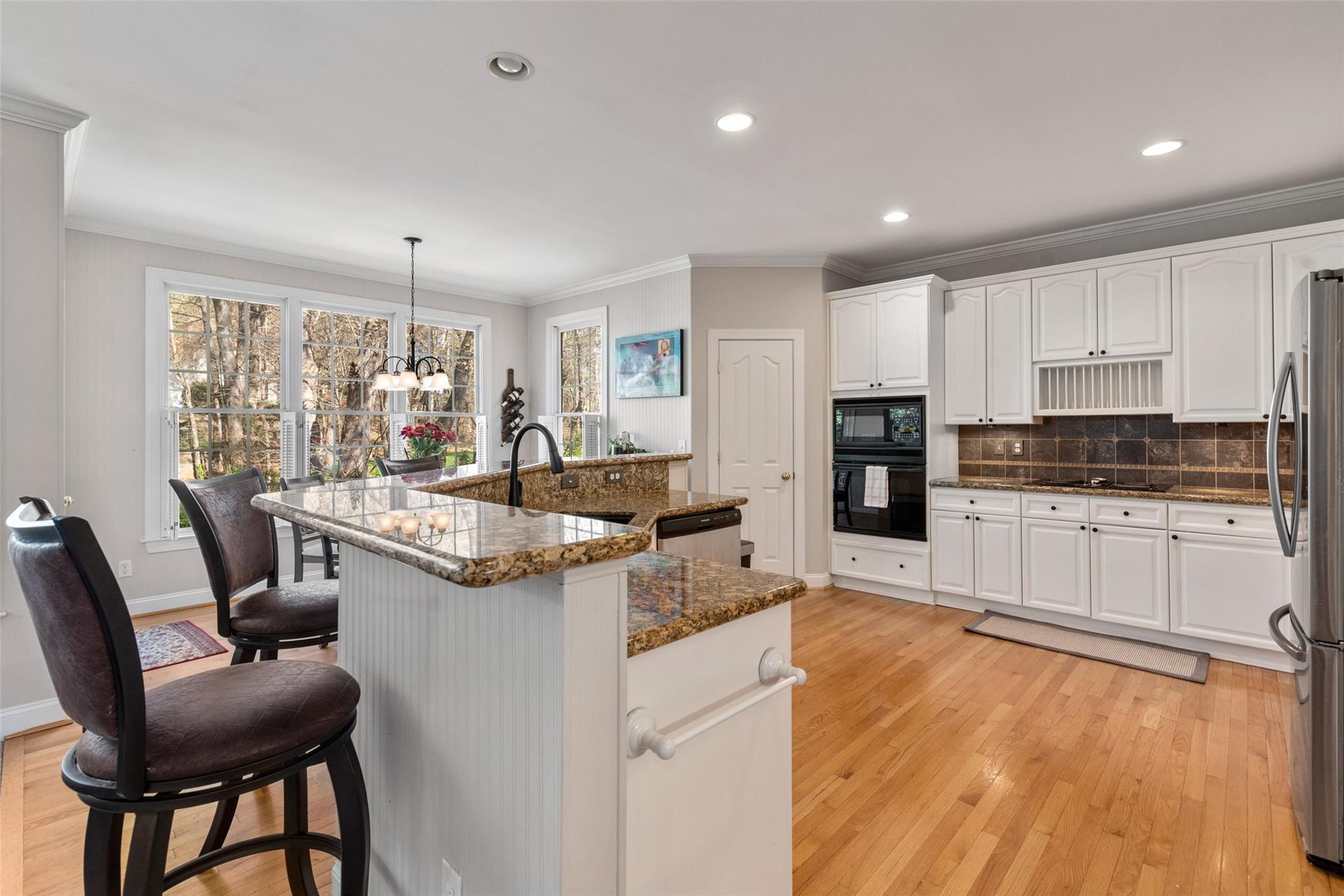 3519 Rhett Butler Place Charlotte, NC 28270 - Photo 14 of 38 a kitchen with stainless steel appliances granite countertop a stove top oven a sink dishwasher and a refrigerator with wooden floor