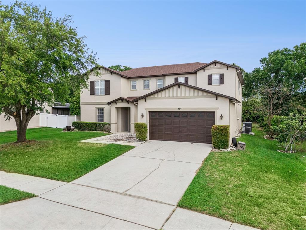 14790 Tullamore Loop Winter Garden, FL 34787 - Photo 3 of 42 a front view of a house with a garden and trees