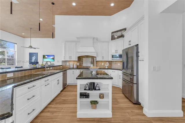 a spacious bedroom with a large bed and a chandelier