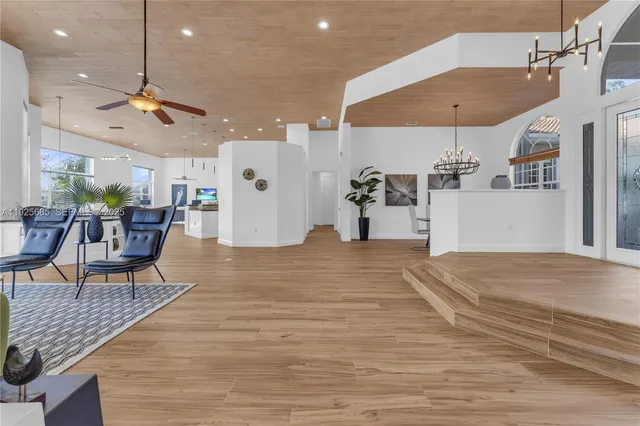 a view of a dining room with furniture a chandelier and wooden floor