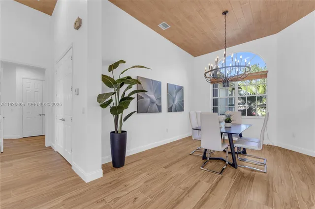 a kitchen with granite countertop white cabinets white appliances a sink and a window