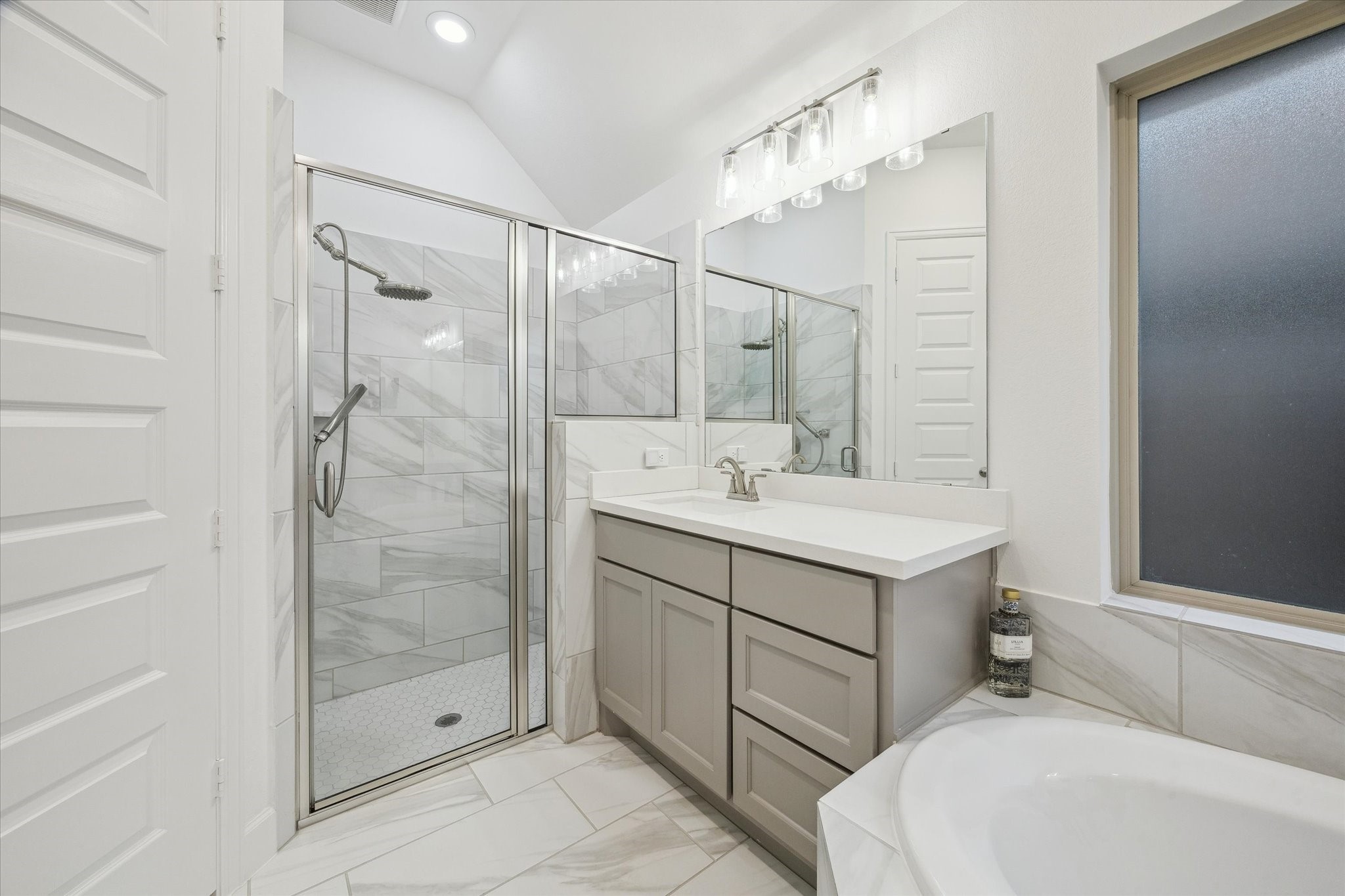 9823 Chapman Trail Manvel, TX 77578 - Photo 21 of 47 The walk-in shower is oversized and features a rain showerhead plus a handheld sprayer. The finishes create a serene and inviting atmosphere.