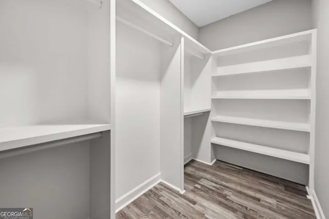 a view of walk in closet with empty racks