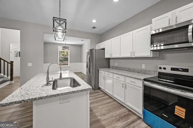 a kitchen with granite countertop a stove sink and microwave