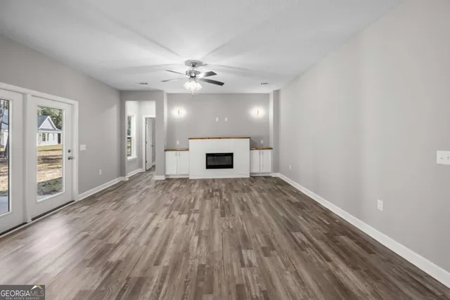 a view of an empty room with a fireplace and a window