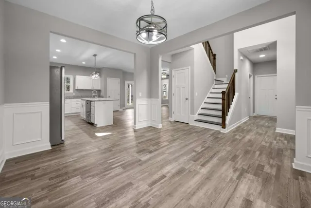 a view of a kitchen with wooden floor and stainless steel appliances