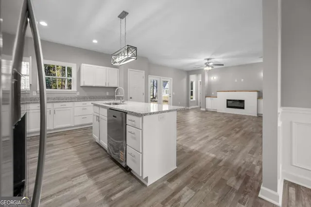 a kitchen with stainless steel appliances granite countertop a stove top oven a sink and a refrigerator