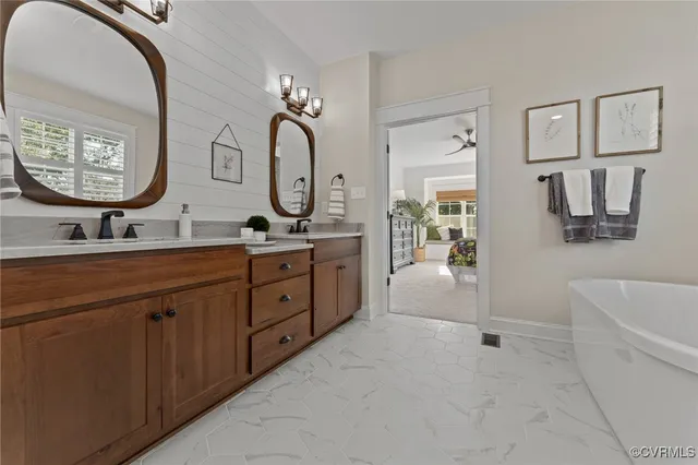 a spacious bathroom with a double vanity sink a mirror a bathtub and a shower