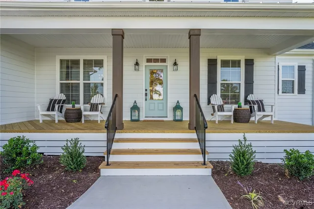 a view of a house with potted plants and couches chairs