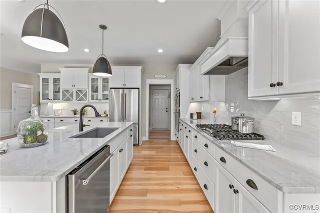 a large kitchen with stainless steel appliances kitchen island a white counter space a sink and cabinets