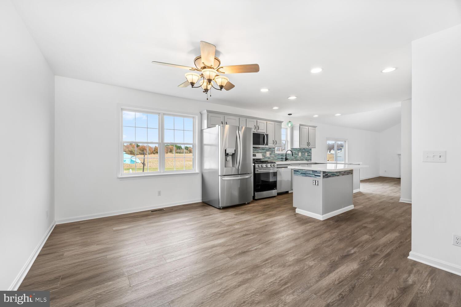 119 Wye Knot Road Queenstown, MD 21658 - Photo 17 of 45 a open kitchen with a refrigerator a stove top oven a sink dishwasher and white cabinets with wooden floor