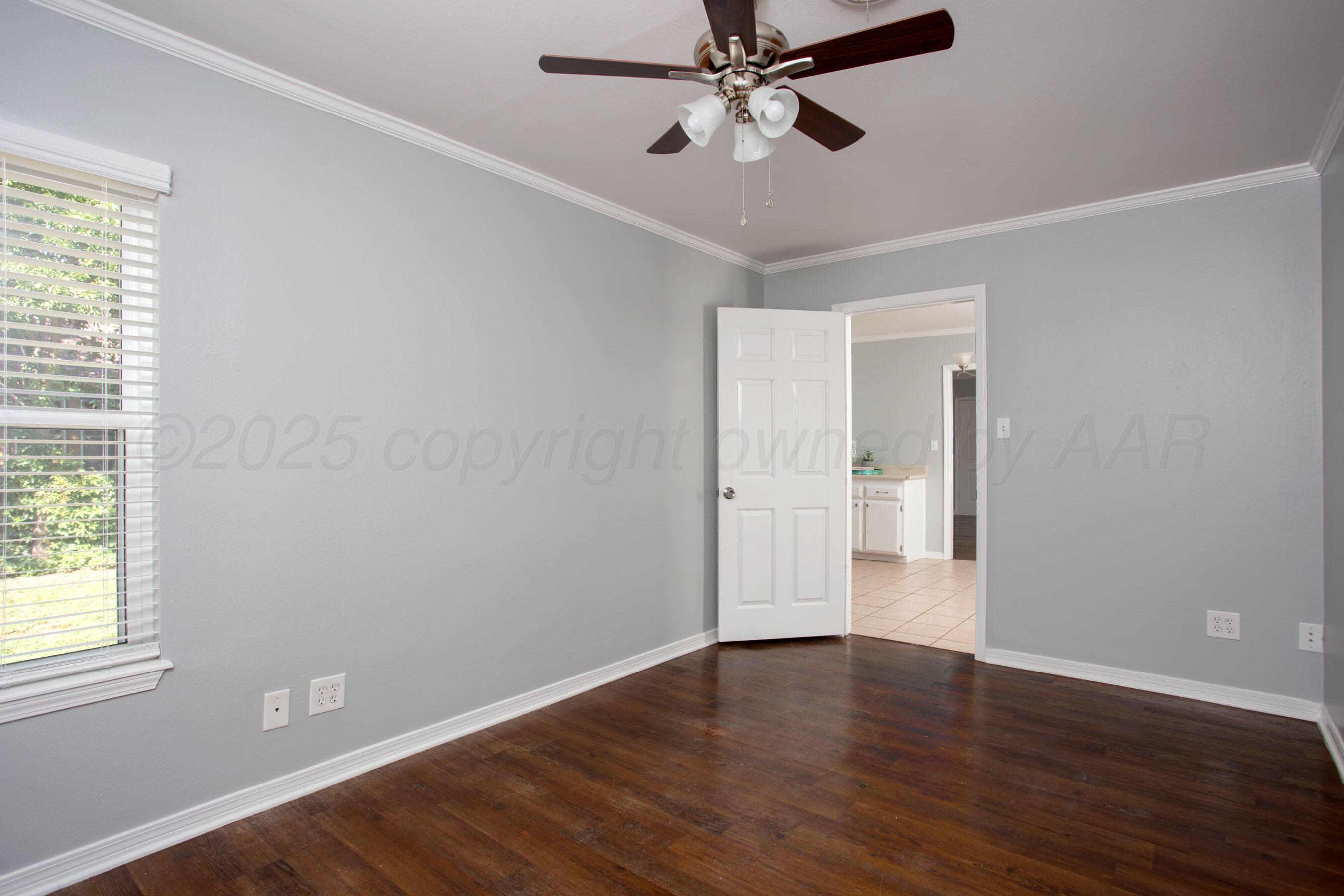 406 Sunset Terrace Amarillo, TX 79106 - Photo 18 of 25 a view of an empty room with wooden floor and a window