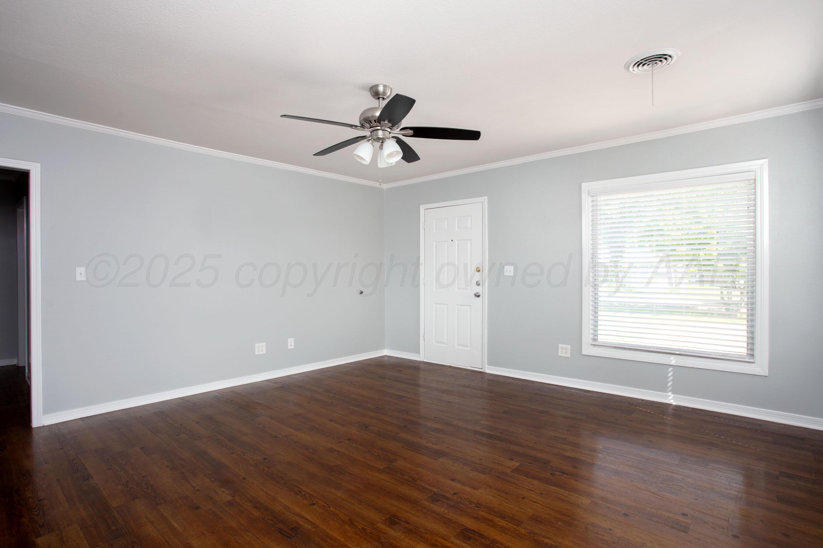 406 Sunset Terrace Amarillo, TX 79106 - Photo 20 of 25 an empty room with wooden floor ceiling fan and windows