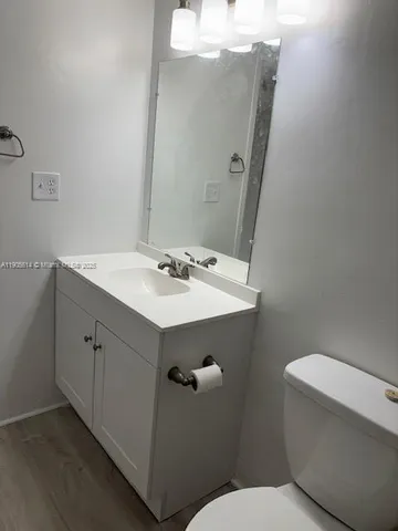 a bathroom with a sink mirror and toilet
