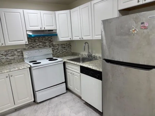 a kitchen with cabinets appliances and a window
