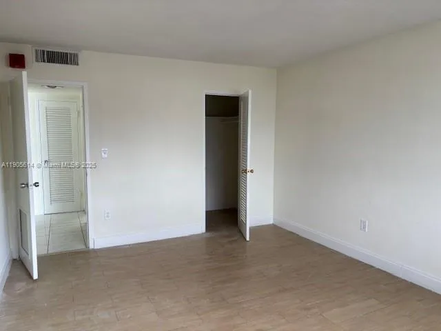 an empty room with closet and a window