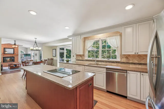 a kitchen that has a sink a stove and chairs