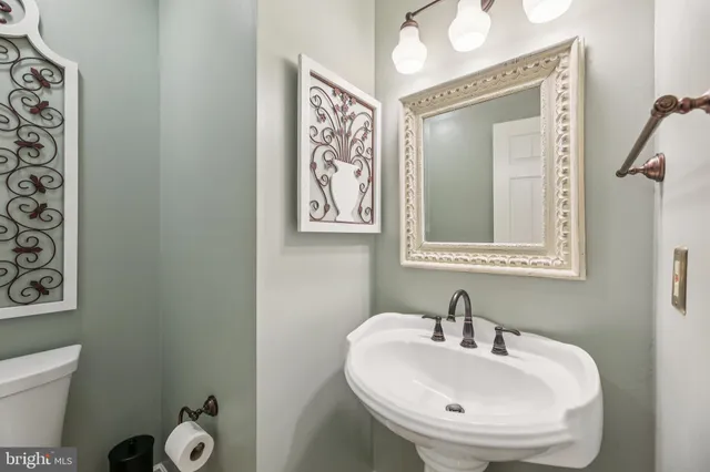 a bathroom with a toilet a sink and a mirror