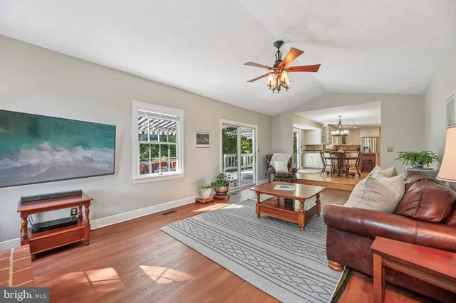 a dining room with wooden floor a chandelier a wooden table and chairs